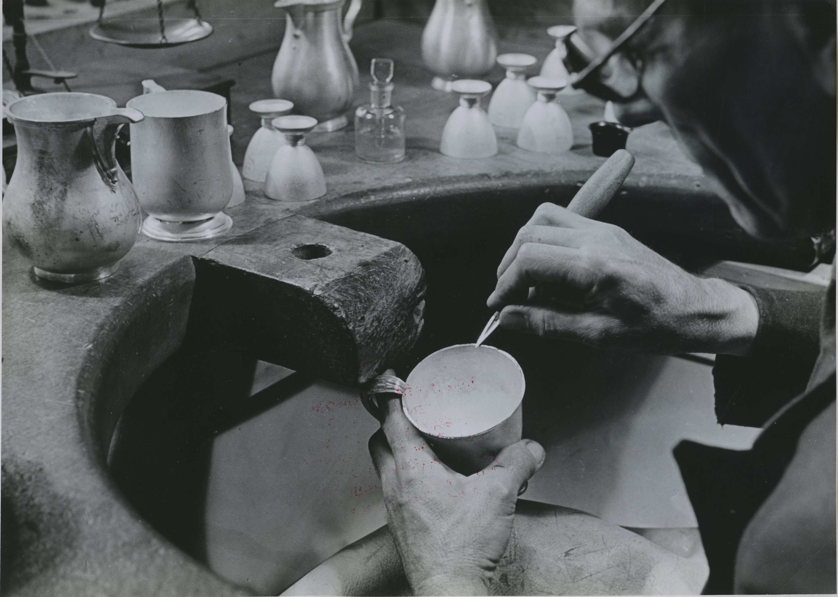 Drawing with a three square the mouth rim of a silver mug